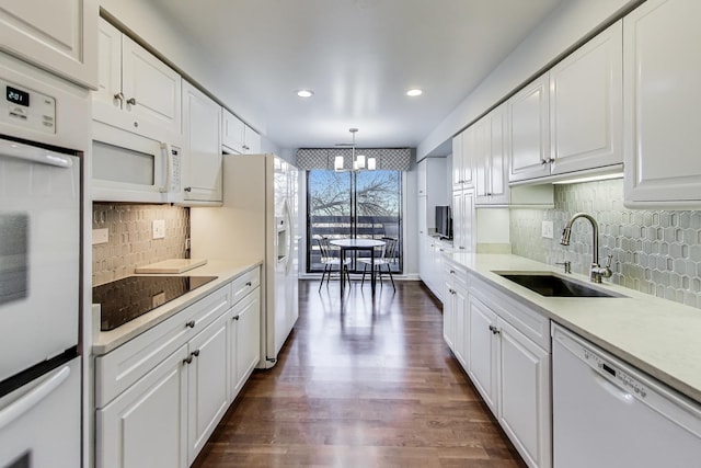 kitchen featuring an inviting chandelier, white appliances, decorative light fixtures, white cabinets, and sink