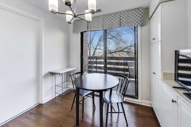 dining area featuring dark wood-type flooring and a chandelier