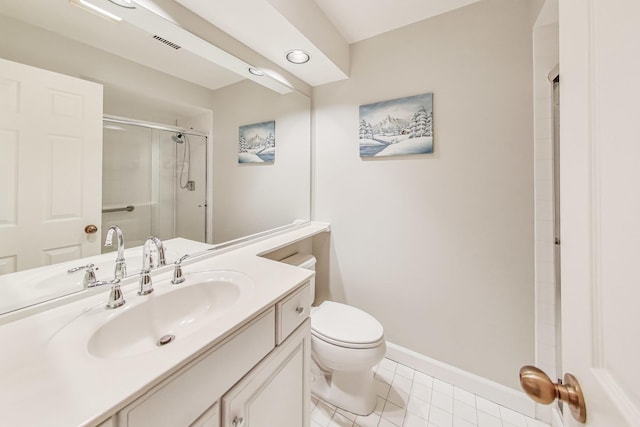 bathroom featuring toilet, vanity, tile patterned floors, and a shower with door