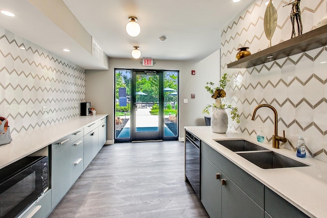 kitchen featuring gray cabinetry, decorative backsplash, black appliances, and sink