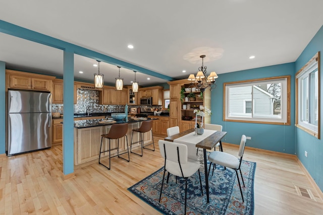 dining room featuring recessed lighting, visible vents, light wood-style flooring, a chandelier, and baseboards