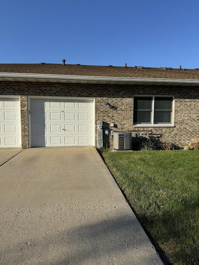 view of front of property featuring central AC, a front lawn, and a garage