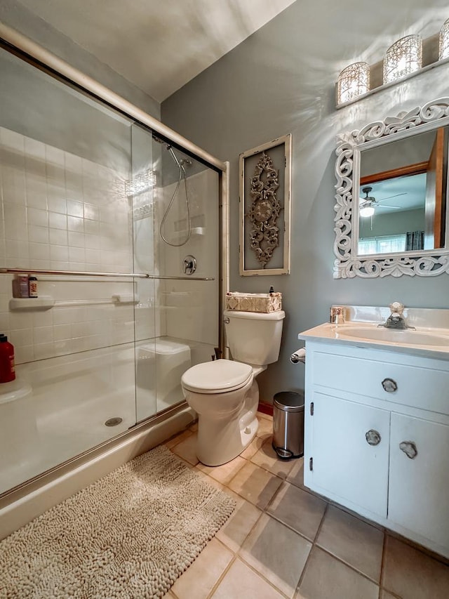 bathroom featuring toilet, tile patterned floors, walk in shower, and vanity