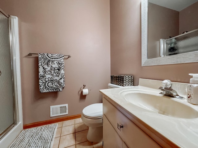 bathroom featuring toilet, tile patterned flooring, a shower with door, and vanity