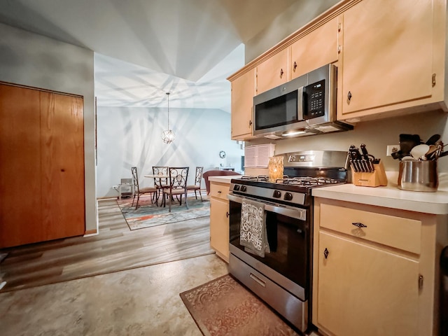 kitchen featuring decorative light fixtures, an inviting chandelier, light brown cabinetry, and appliances with stainless steel finishes