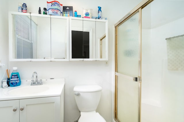 bathroom featuring toilet, walk in shower, and vanity