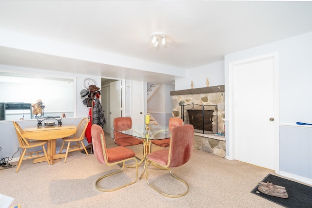 carpeted dining room with a fireplace