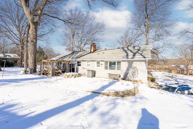 snow covered back of property with cooling unit