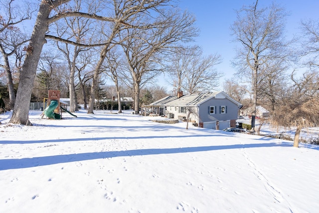 yard covered in snow with a playground