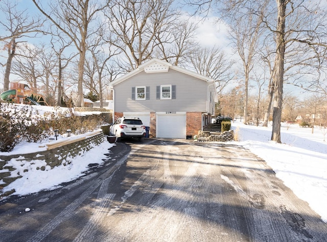 view of snowy exterior with a garage