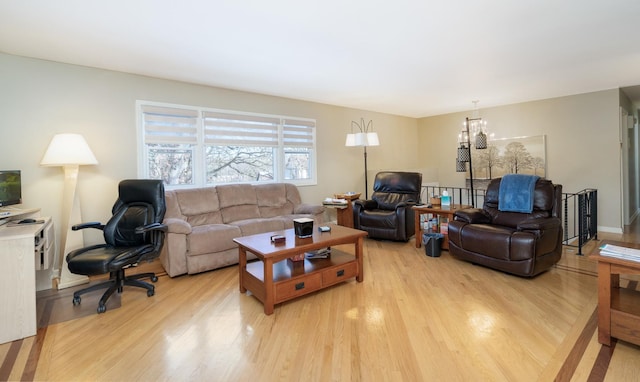 living room with light wood-type flooring and an inviting chandelier