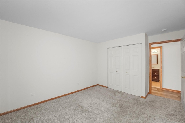 unfurnished bedroom featuring light carpet and a closet