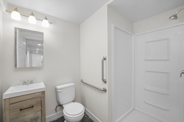 bathroom featuring toilet, vanity, and a shower