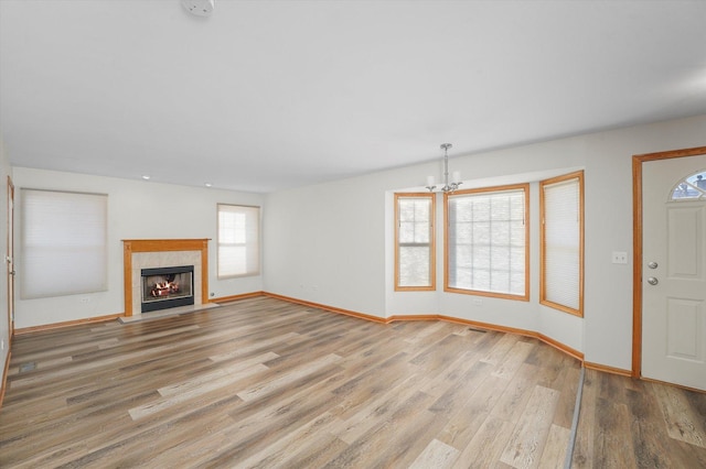 unfurnished living room featuring a chandelier and hardwood / wood-style floors