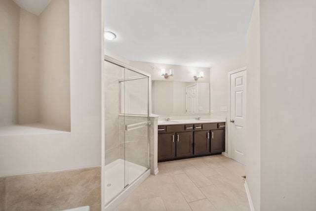 bathroom with a shower with door, vanity, and tile patterned floors