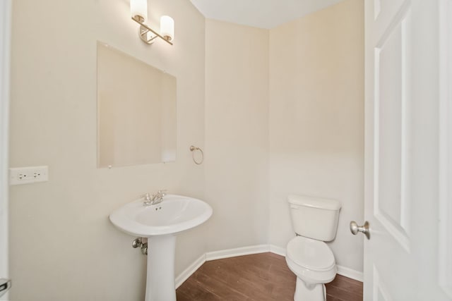 bathroom featuring toilet, sink, and hardwood / wood-style flooring