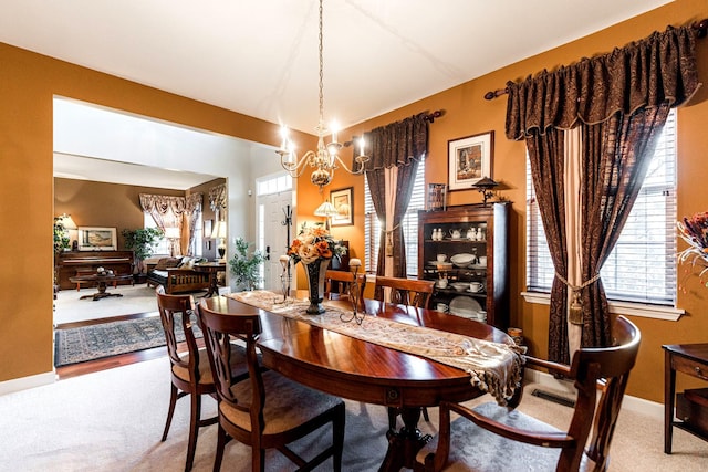 dining area featuring carpet and an inviting chandelier