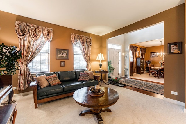 carpeted living room with an inviting chandelier