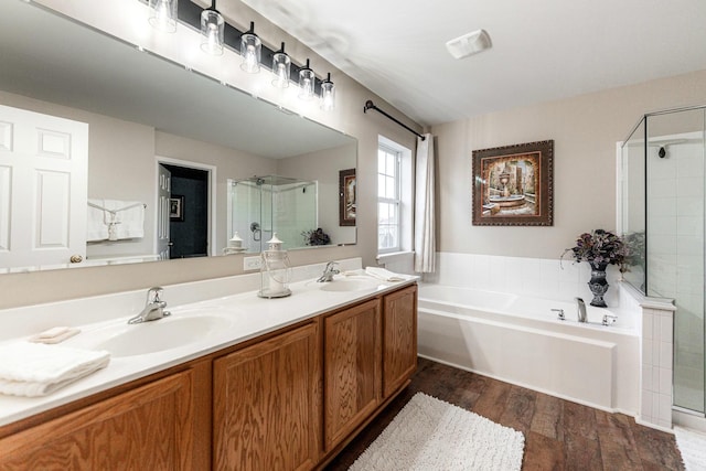 bathroom with wood-type flooring, vanity, and plus walk in shower