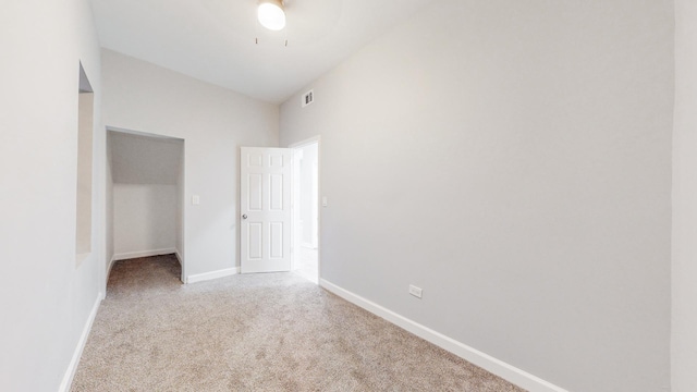 unfurnished bedroom featuring a closet, light colored carpet, and ceiling fan