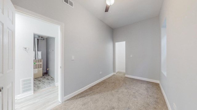 spare room featuring ceiling fan and light colored carpet