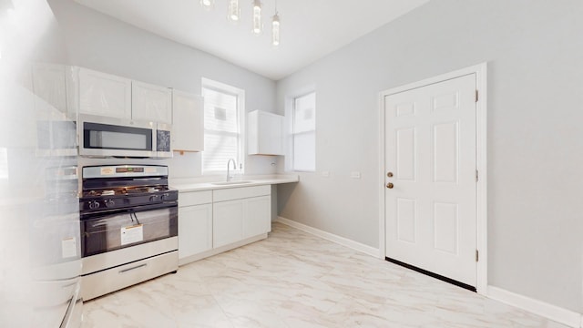 kitchen with sink, range with gas stovetop, and white cabinetry