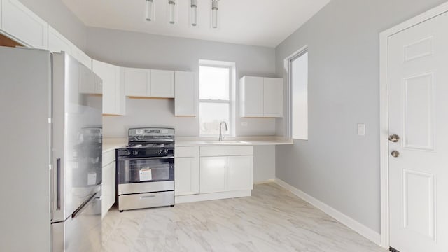 kitchen featuring stainless steel appliances, white cabinetry, and sink