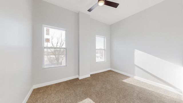 carpeted spare room featuring ceiling fan