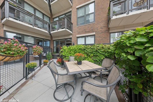 balcony with outdoor dining area and a patio area