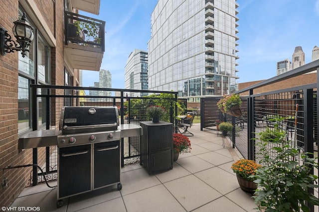 view of patio with a balcony, a view of city, and grilling area