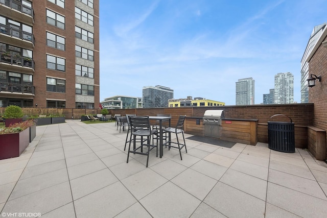 view of patio with a city view, an outdoor kitchen, and area for grilling