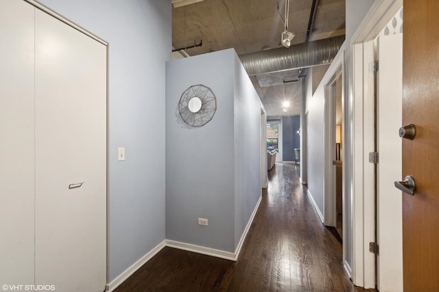 hall featuring baseboards and dark wood-style flooring