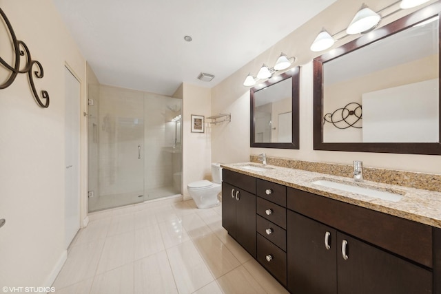 full bathroom with toilet, a shower stall, double vanity, and a sink