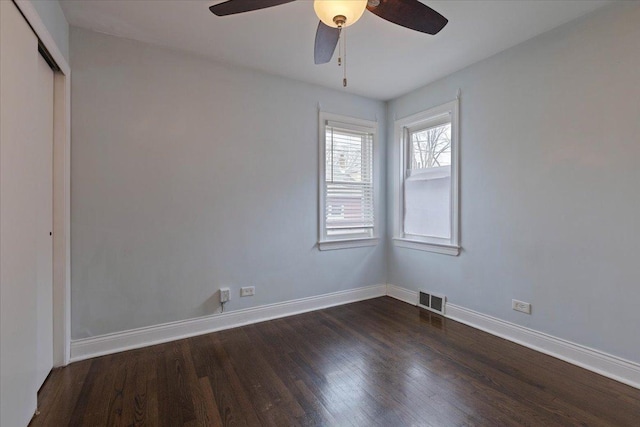 spare room featuring ceiling fan and dark wood-type flooring