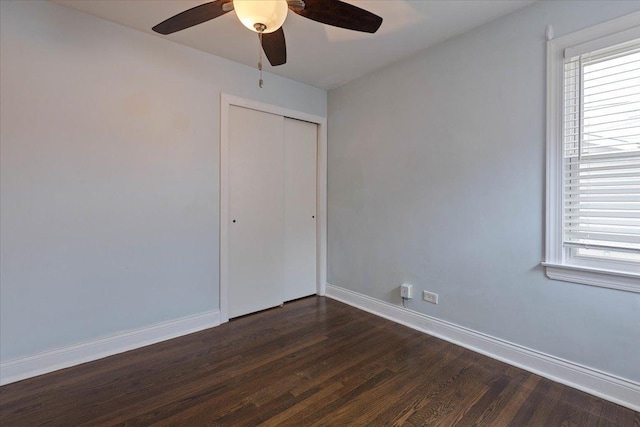 unfurnished bedroom featuring ceiling fan, dark hardwood / wood-style flooring, and a closet