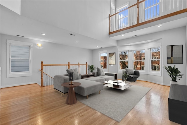 living room featuring a high ceiling and light wood-type flooring