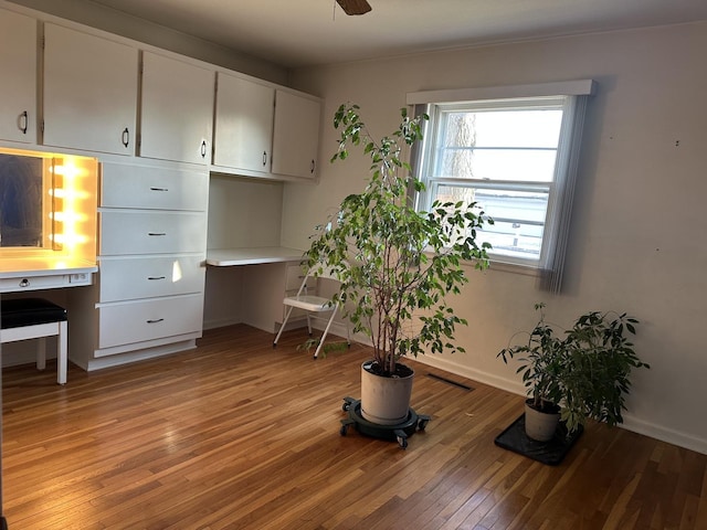 misc room with ceiling fan, built in desk, and light hardwood / wood-style flooring