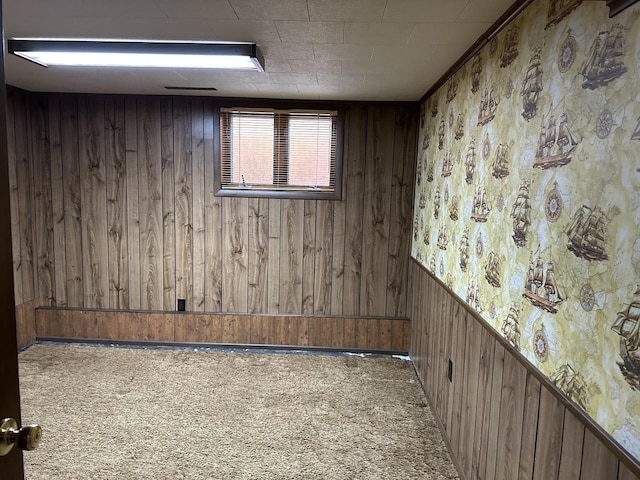 carpeted empty room with wood walls