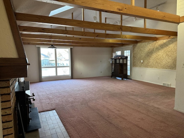 unfurnished living room with vaulted ceiling with beams and carpet