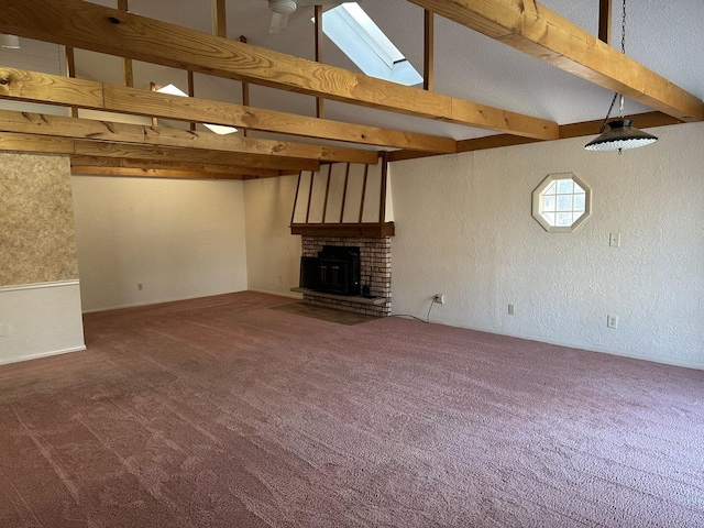 unfurnished living room with a brick fireplace, high vaulted ceiling, a skylight, and carpet flooring