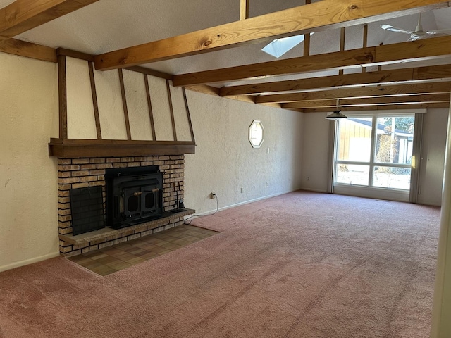 unfurnished living room featuring carpet floors, ceiling fan, a skylight, and beam ceiling