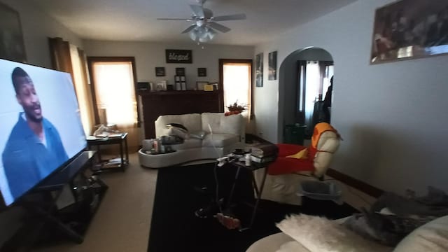 living room featuring ceiling fan and a healthy amount of sunlight