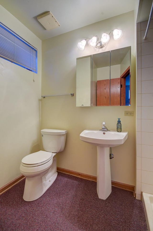 bathroom featuring a shower, sink, and toilet