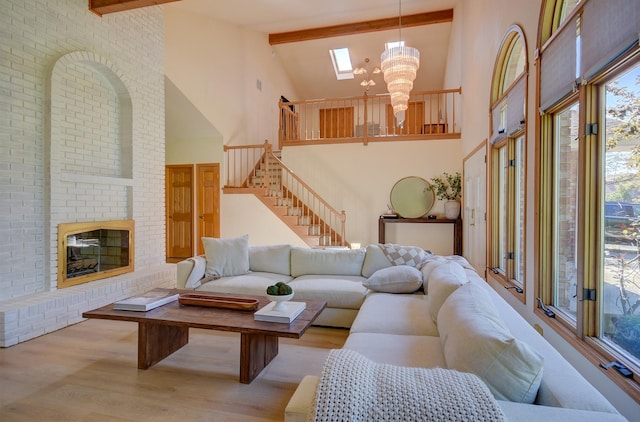 living room with beamed ceiling, a brick fireplace, light wood-type flooring, and high vaulted ceiling