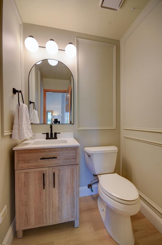 bathroom with vanity, hardwood / wood-style flooring, and toilet