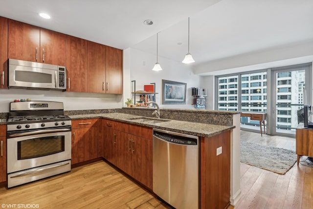 kitchen with sink, decorative light fixtures, stainless steel appliances, and kitchen peninsula