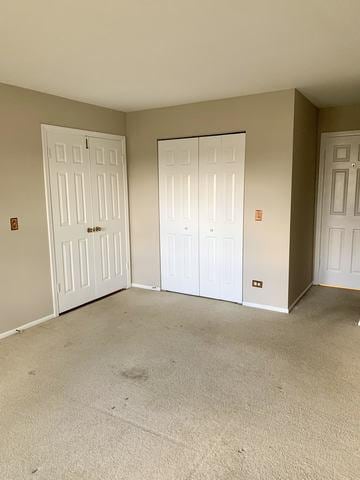 unfurnished bedroom with multiple closets and carpet floors