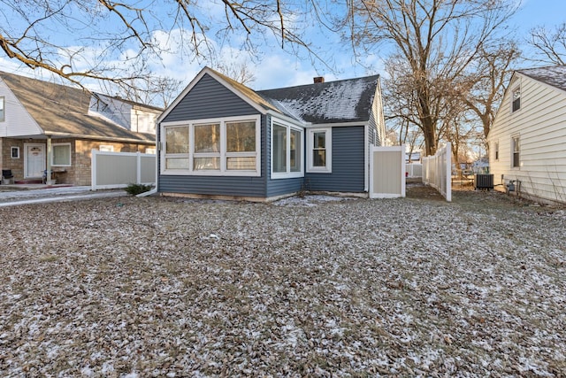 back of property with central AC unit and a sunroom