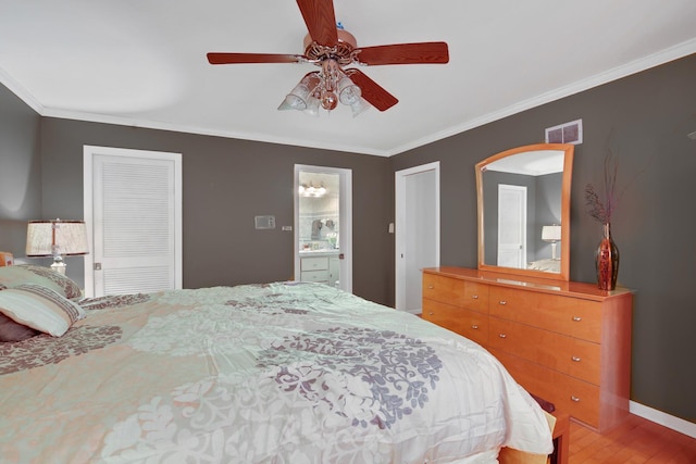 bedroom featuring visible vents, ornamental molding, a ceiling fan, wood finished floors, and baseboards