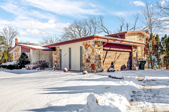 exterior space featuring an attached garage and stone siding